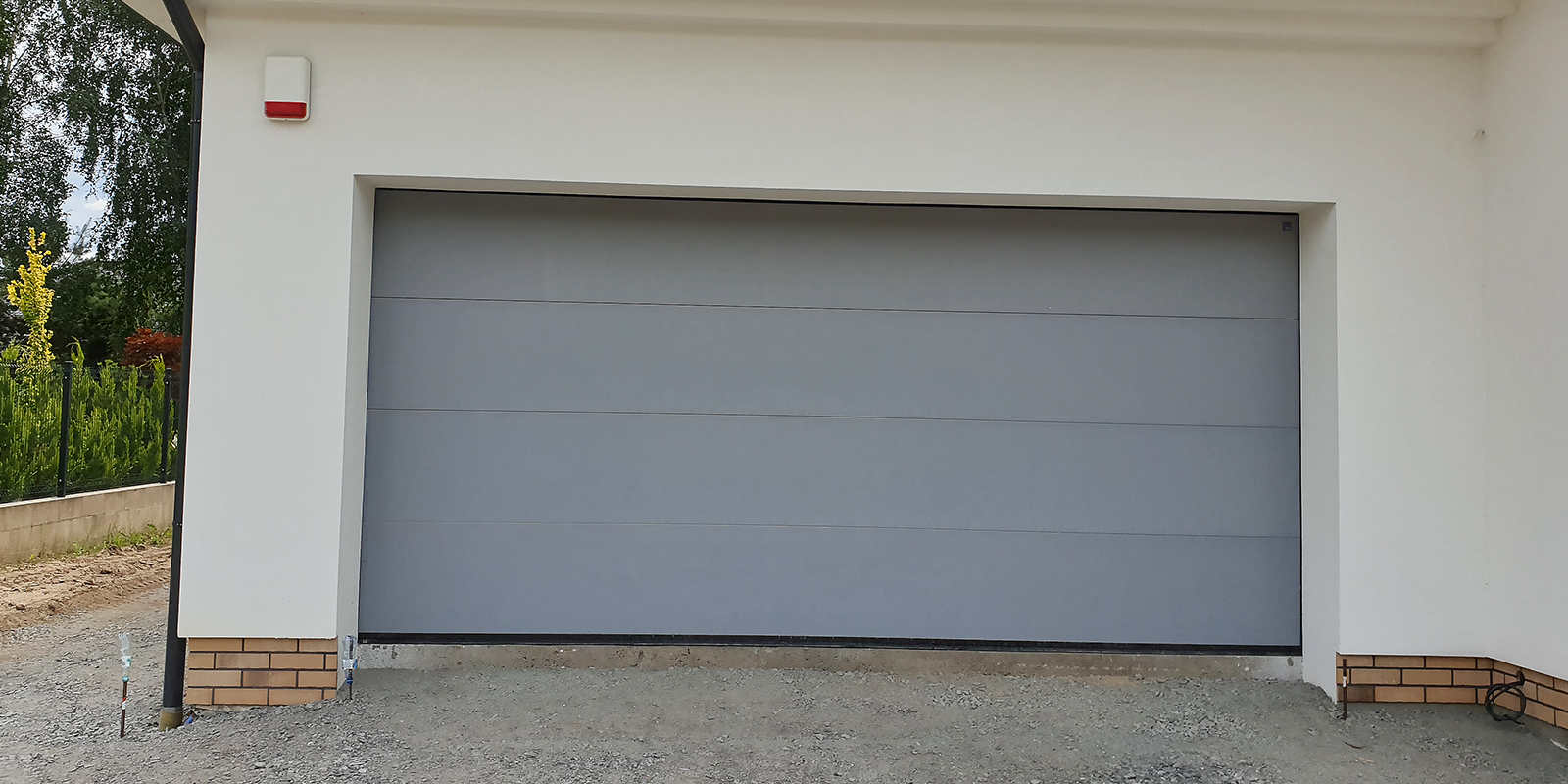 Brama garażowa to naturalne uzupełnienie stolarki okiennej i drzwiowej.